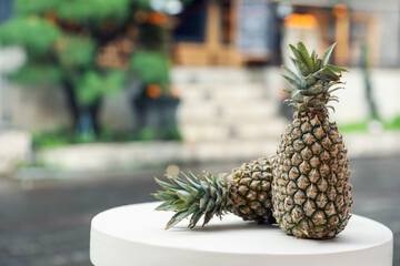 Fresh ripe pineapples on white table outdoors, space for text