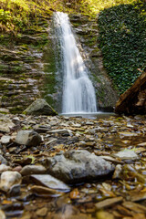 A waterfall is flowing down a rocky cliff