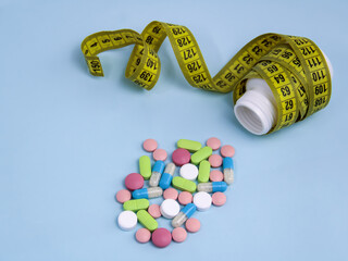 a white jar with weight loss pills and a measuring tape on a blue background, an even strip