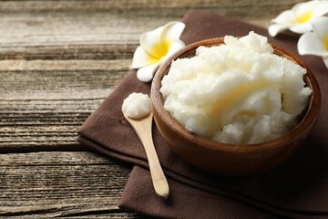 Natural shea butter and plumeria flowers on wooden table, closeup. Space for text