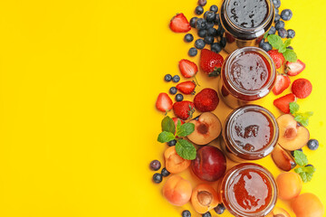 Different jams in jars and ingredients on yellow background, flat lay. Space for text