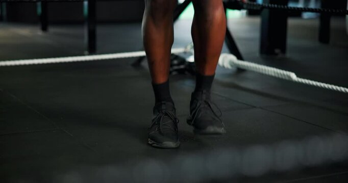 Feet, person and skipping rope at gym for fitness, warm up routine and preparation for boxing match. Legs, boxer and jump with equipment for getting ready, endurance training and workout challenge