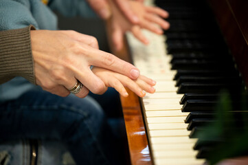 Fototapeta premium Piano lesson filled with joy as a parent teaches a child the magic of music at a cozy home during a sunny afternoon