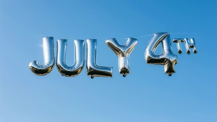 Silver July 4th metallic balloons floating against a clear blue sky. Bright decor for Independence Day celebration footage. - Powered by Adobe