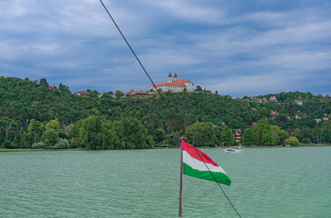 Tihany Abbey viewed from a ship with the Hungarian flag in the front at Lake Balaton, Hungary.
