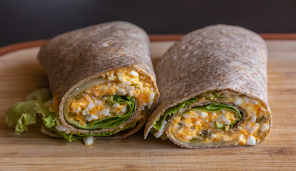 Devil egg wraps healthy breakfast on wooden cutting board. Close-up photo of a fresh, light meal...