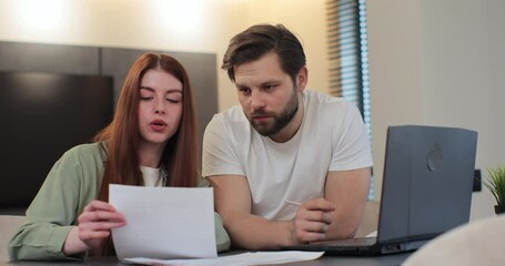 Man and woman with paperwork, inflation and frustrated with financial review and problem. Couple stressing about budget, savings and finance while working on debt bills with laptop at home. - Powered by Adobe