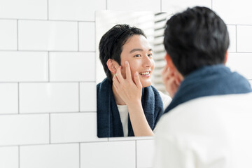 自宅の洗面所で身だしなみを整える若い日本人男性