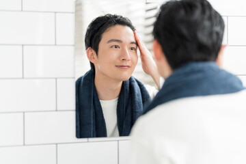 自宅の洗面所で身だしなみを整える若い日本人男性