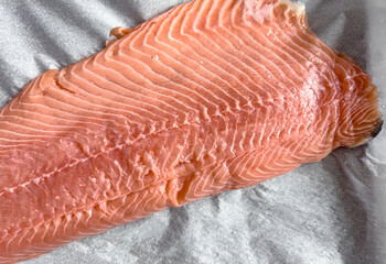 Raw salmon fillet ready for baking, fresh seafood prepared for healthy cooking, concept of nutritious marine food and culinary preparation