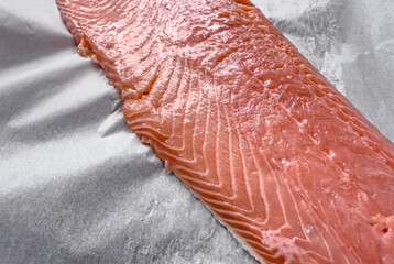 Raw salmon fillet ready for baking, fresh seafood prepared for healthy cooking, concept of nutritious marine food and culinary preparation
