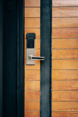 smart digital door lock on closed wooden door with dark grey concrete wall , modern lifestyle concepts