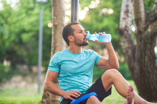 Sportsman taking break during workout drinking water bottle