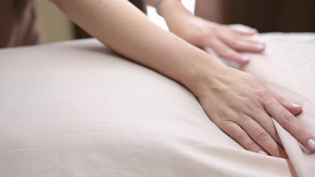 Beautician preparing massage table for client