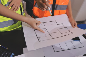 Closeup of team of industrial engineers meeting analyze machinery blueprints consult project on table in manufacturing factory. Working in manufacturing plant or production plant.