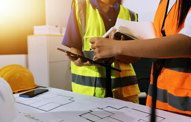 Closeup of team of industrial engineers meeting analyze machinery blueprints consult project on table in manufacturing factory. Working in manufacturing plant or production plant.