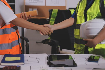 Closeup of team of industrial engineers meeting analyze machinery blueprints consult project on table in manufacturing factory. Working in manufacturing plant or production plant.