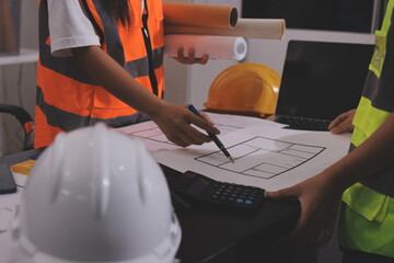 Closeup of team of industrial engineers meeting analyze machinery blueprints consult project on table in manufacturing factory. Working in manufacturing plant or production plant.
