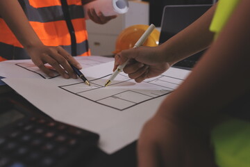 Closeup of team of industrial engineers meeting analyze machinery blueprints consult project on table in manufacturing factory. Working in manufacturing plant or production plant.