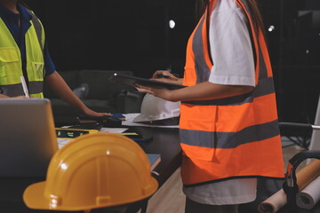 Closeup of team of industrial engineers meeting analyze machinery blueprints consult project on table in manufacturing factory. Working in manufacturing plant or production plant.
