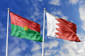 Flags of Burkina Faso and Bahrain wave together, symbolizing unity and diversity under a bright sky,