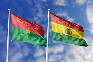 A Burkina Faso and Bolivia flag, a metaphor for South American-African unity, wave together against a blue sky, symbolizing friendship and cultural exchange.