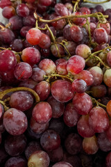 Close-up of fresh red grapes with a natural bloom on the skin, arranged in a tight cluster. The image highlights texture, freshness, and vibrant color, ideal for food concepts.