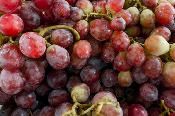 Close-up of fresh red grapes with a natural bloom on the skin, arranged in a tight cluster. The image highlights texture, freshness, and vibrant color, ideal for food concepts.