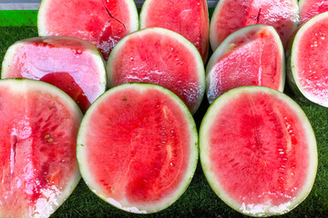Top view of freshly cut red watermelons on display, showcasing their juicy texture, vibrant color,...
