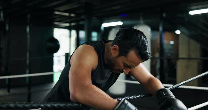 Fitness, boxing ring and tired man on rope for break, relax or exhausted with challenge. Athlete, boxer and rest in gym for breathing, fatigue or workout recovery with intense pain for fight or sport
