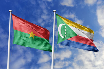 A Burkina Faso and Comoros flag, a metaphor for Indian Ocean-African ties, wave together against a blue sky, symbolizing friendship and cultural exchange.
