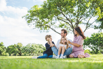 Obraz premium Happy family parent children having picnic outdoor activity. Enjoy happiness moment summer playing together including father mother son and daughter relaxing in the morning sunrise.