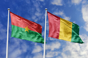 A Burkina Faso and Mali flag, a metaphor for West African brotherhood, wave together against a blue...
