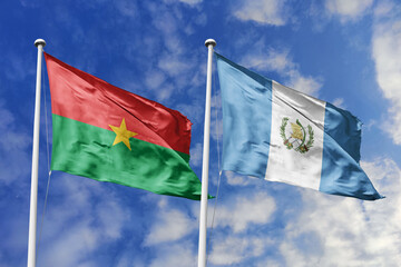 A Burkina Faso and Guatemala flag, a metaphor for global unity, wave together against a blue sky, symbolizing friendship and cultural exchange.