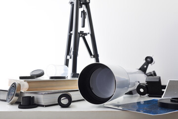 View of a telescope lens on white table with tools