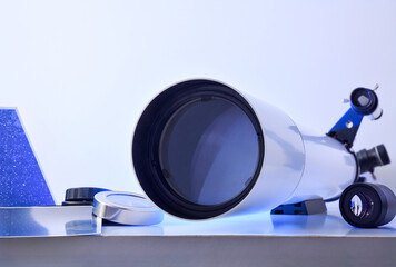View of a telescope lens on white table with tools