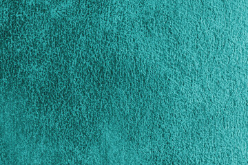 Close up, macro structure of turquoise suede fabric with abstract embossed shabby, messy texture. Upholstery, decorative cloth structure, canvas for home decor. Background, backdrop, wallpaper.