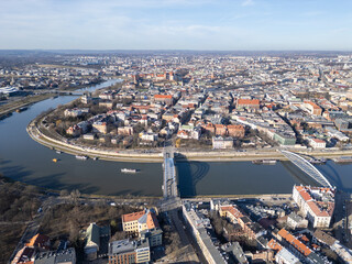 Krakow, Poland: Aerial view of the historic Kazimierz district and the Father Bernatek’s Bridge over the Vistula river in Krakow on a sunny winter day in Poland.