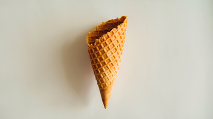 A waffle cone, typically used for serving ice cream. It's elongated and slightly curved, with a textured, crisscross pattern on its surface.