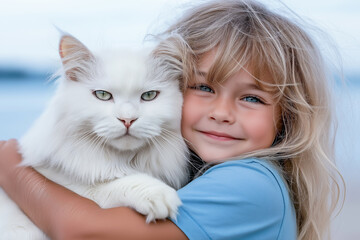 A 5-7 year old girl with blonde hair in a blue t-shirt hugs a white fluffy cat
