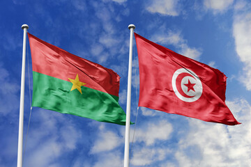 A Burkina Faso and Tunisia flag, a metaphor for North-South African unity, wave together against a blue sky, symbolizing friendship and cooperation.
