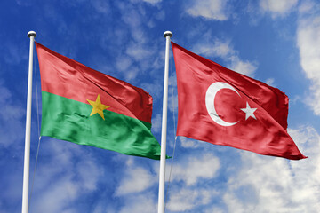 A Burkina Faso and Turkey flag, a metaphor for historical ties, wave together against a blue sky, symbolizing friendship and cultural exchange.