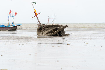 A boat is on the beach with a flag on it