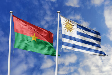 A Burkina Faso and Uruguay flag, a metaphor for South-South collaboration, wave together against a blue sky, symbolizing unity and cultural exchange.