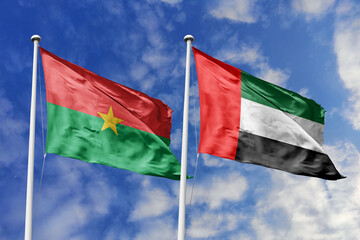 A Burkina Faso and UAE flag, a metaphor for global trade ties, wave together against a blue sky,...