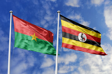 A Burkina Faso and Uganda flag, a metaphor for East-West African unity, wave together against a blue sky, symbolizing friendship and cooperation.