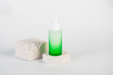 Green glass cosmetic bottle, Skin care or sunscreen cosmetic with stylish props on white background.