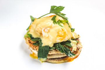 eggs benedict with toast and spinach isolated on white background