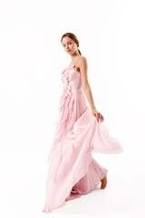 Fototapeta premium Model showcases elegant pink gown in minimalist studio setting during a fashion shoot