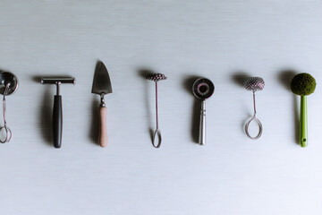 Minimalist arrangement of various kitchen tools, including peeler, spatula, and whisk, showcasing modern and eco friendly aesthetic. This setup emphasizes functionality and style